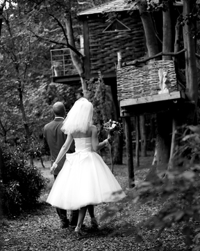Bride and Groom walking to tree house accommodation on their wedding day at North Hill Farm, Chorleywood, Hertfordshire