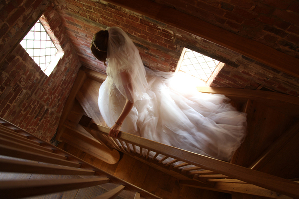 Bride walking down staircase at Micklefield Hall